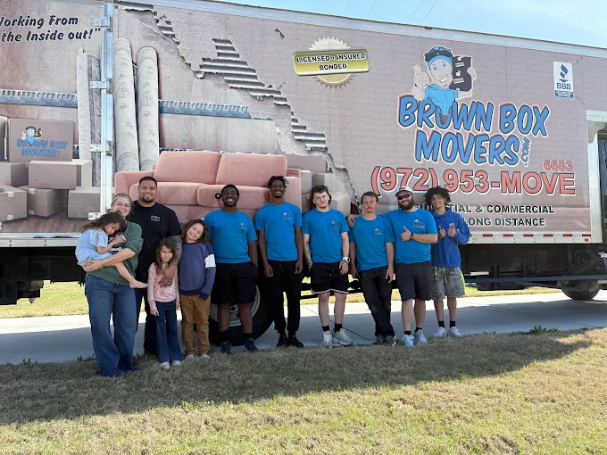 Brown Box Movers crew posing together beside a company truck