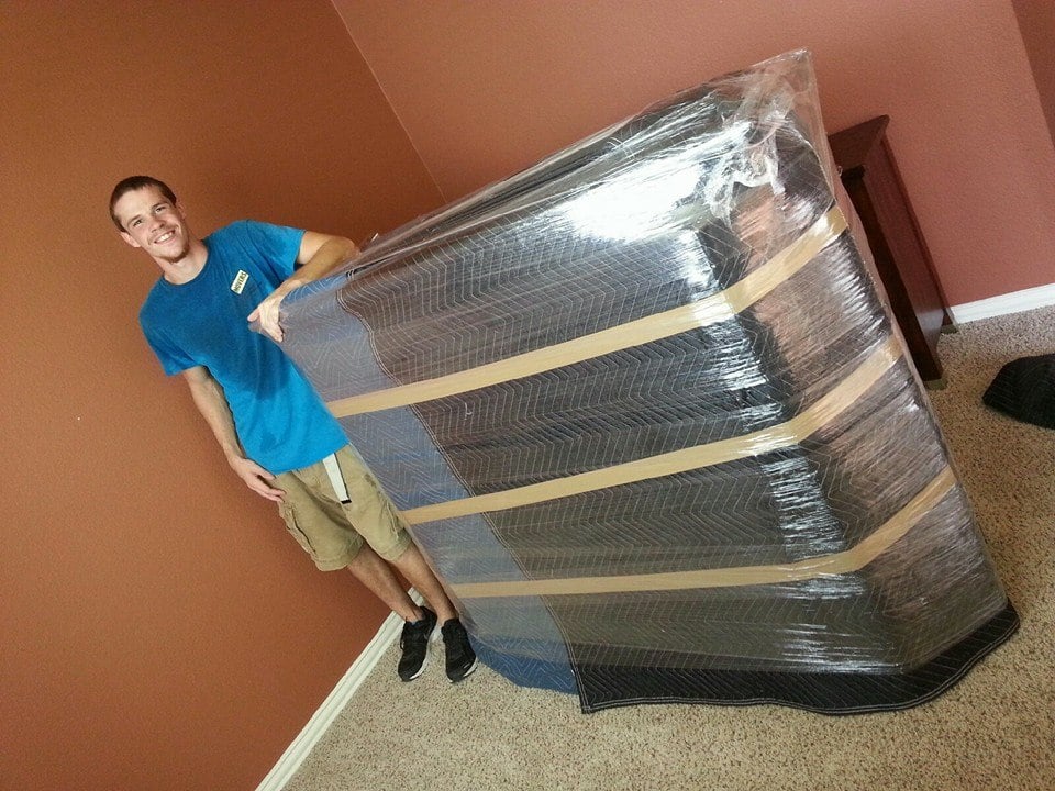 Mover wrapping furniture in plastic