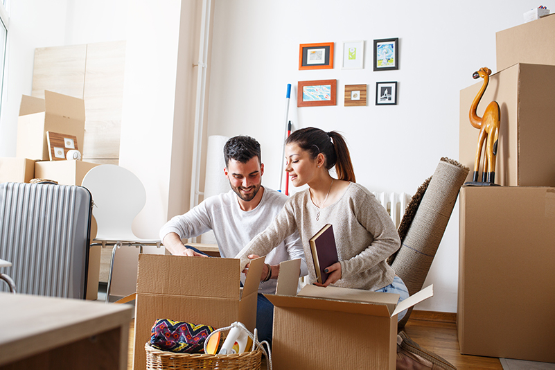 Couple packing moving boxes in their living room