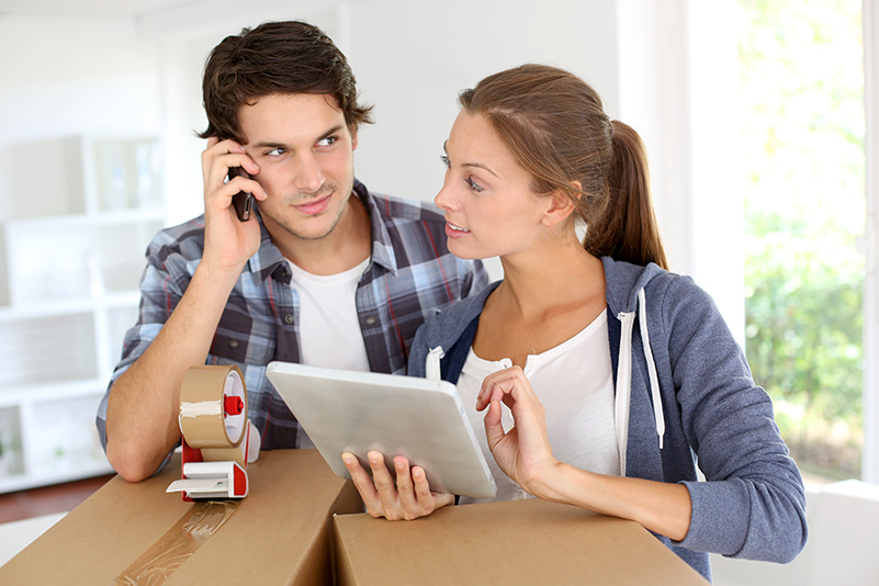 Couple using a phone and tablet to plan an interstate move