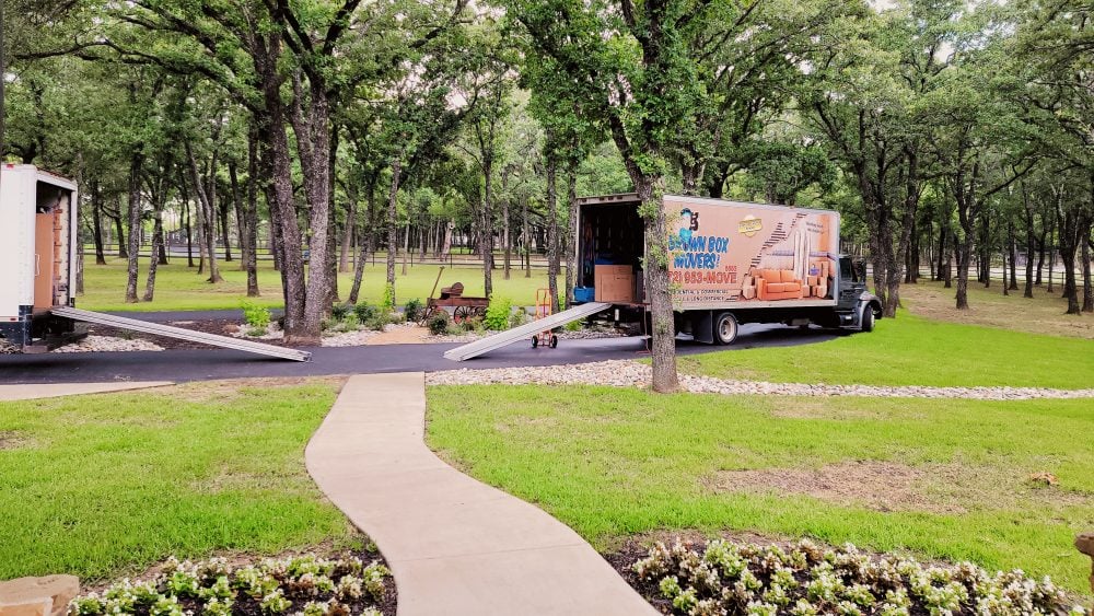 Brown Box Movers truck at a tree-lined property