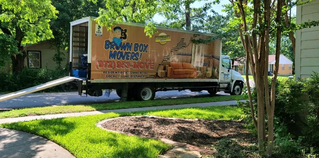 Brown Box Movers truck on a tree-lined street before a long-distance move