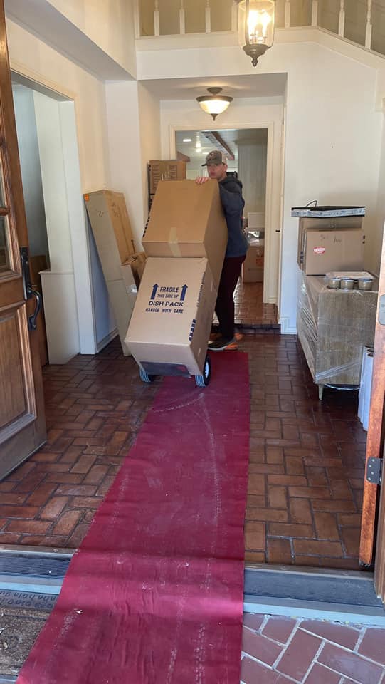 Hallway lined with boxes and furniture ready for the movers