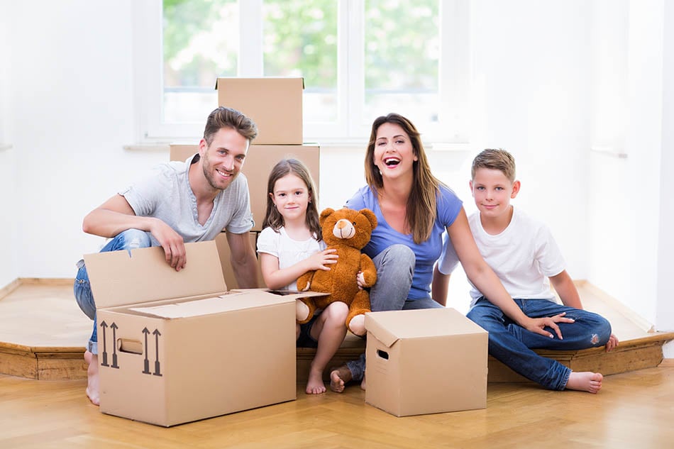 Family relaxing among moving boxes after relocating to Dallas-Fort Worth