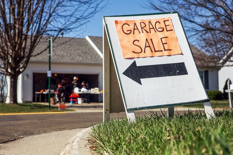 Garage sale sign posted in a front yard