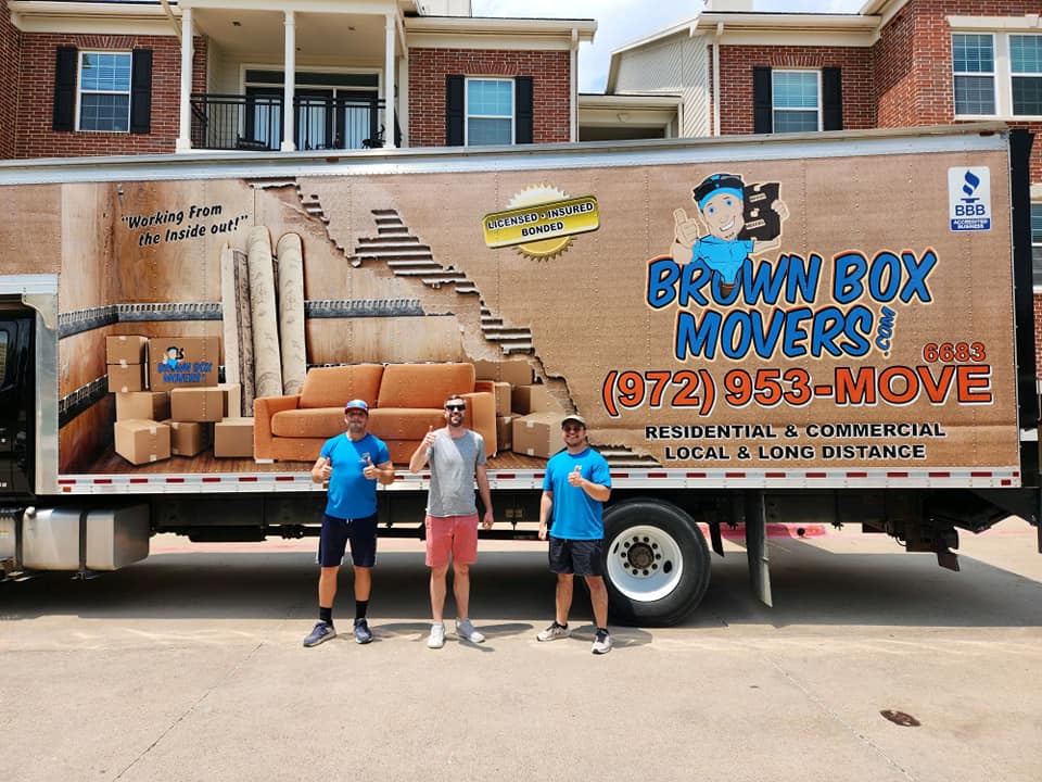 Brown Box Movers crew standing beside a company truck