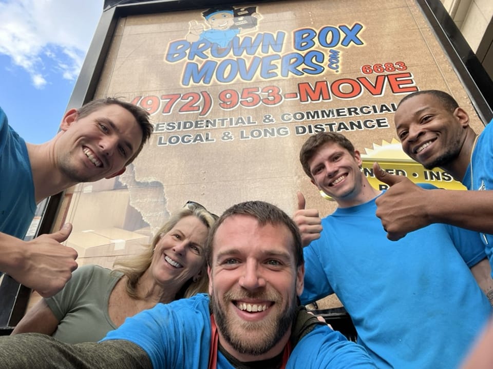 Brown Box Movers crew taking a selfie in front of their truck