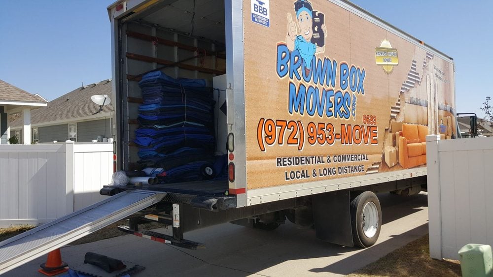 Open moving truck with ramp and blankets ready for loading