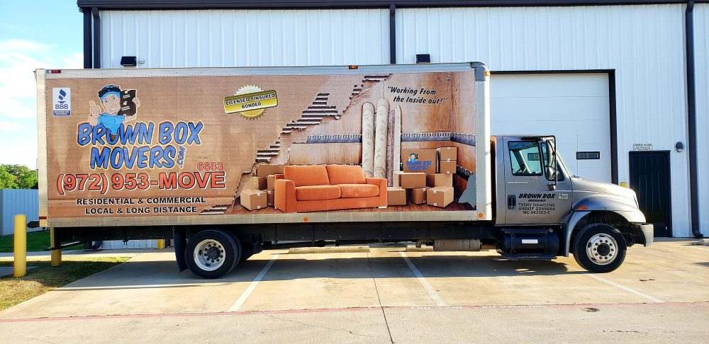 Brown Box Movers truck parked outside a commercial office building