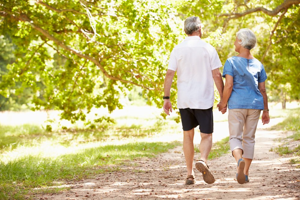 Senior couple walking together through a park